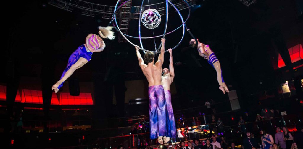 Acrobats hanging from a suspended sphere